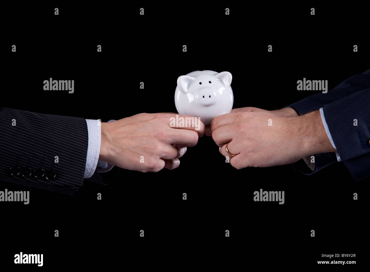 Due proprietari in lizza per il denaro, spingendo un salvadanaio (isolato su nero) Foto Stock