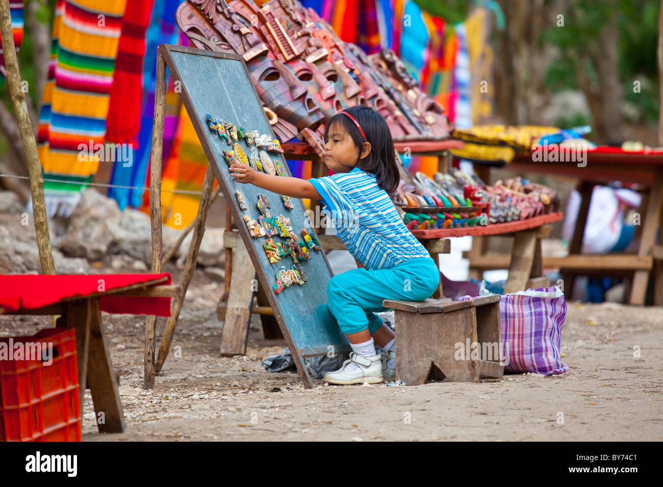 Piccolo messicano ragazza presso i suoi genitori stand di souvenir, Chichen Itza, Messico Foto Stock