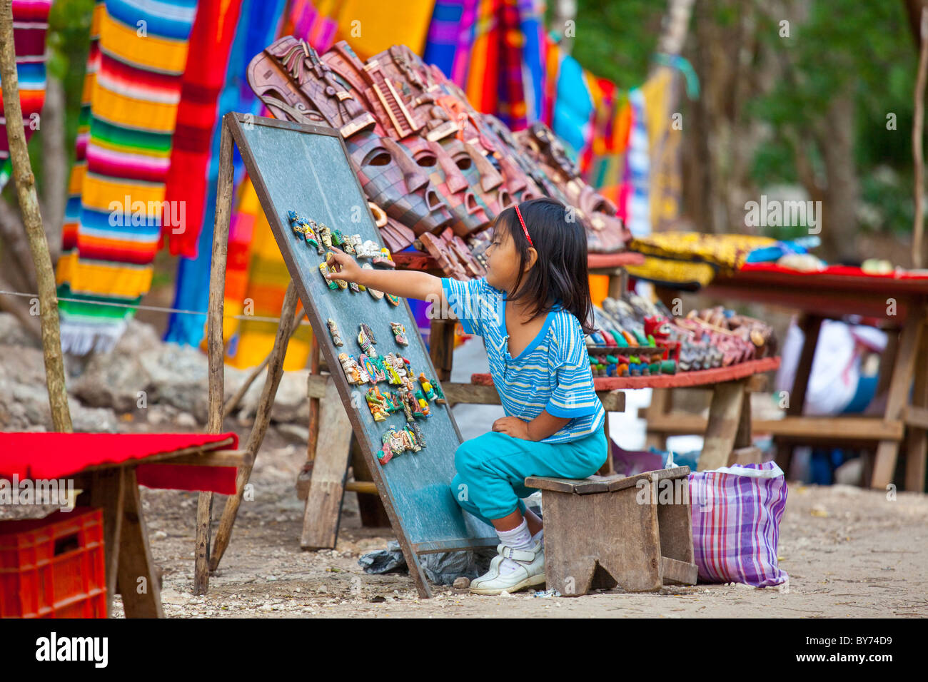 Piccolo messicano ragazza presso i suoi genitori stand di souvenir, Chichen Itza, Messico Foto Stock