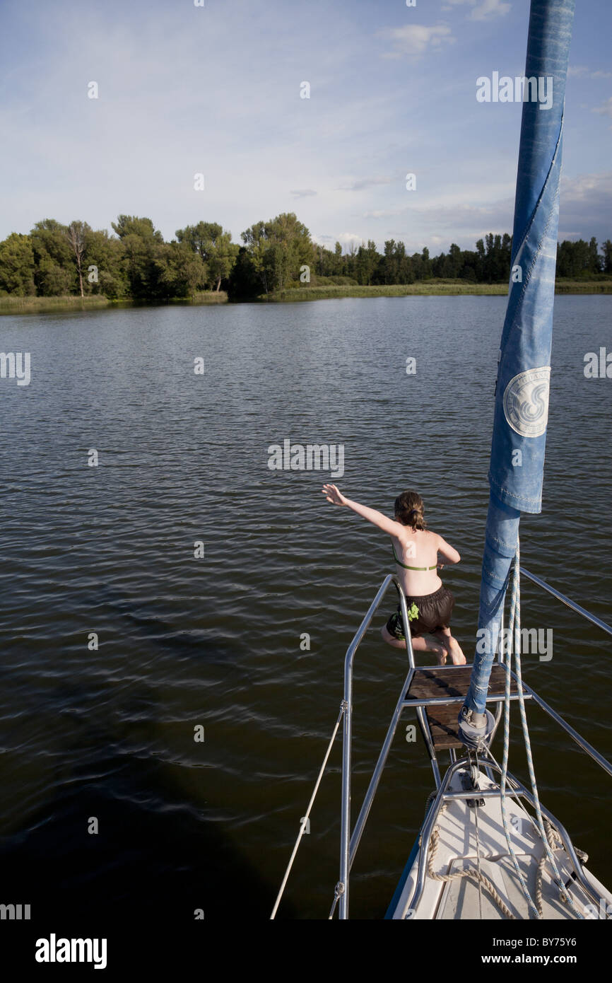 La ragazza che salta da una barca a vela nel lago Beetzsee, Brandenburg an der Havel, Brandeburgo, Germania Foto Stock