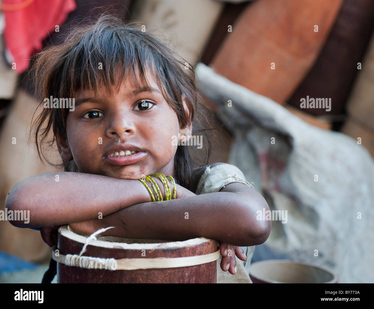 I giovani poveri di casta inferiore Indian street ragazza di proferire Pradesh poggiando su metà realizzati i tamburi. Il tamburo makers bambini. Foto Stock