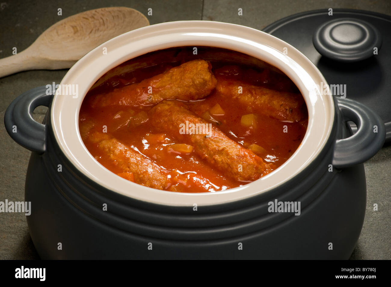 Casseruola di salsiccia vegetariana cotta in una pentola di ceramica rotonda grigia con il coperchio rimosso, pronta per servire. Foto Stock