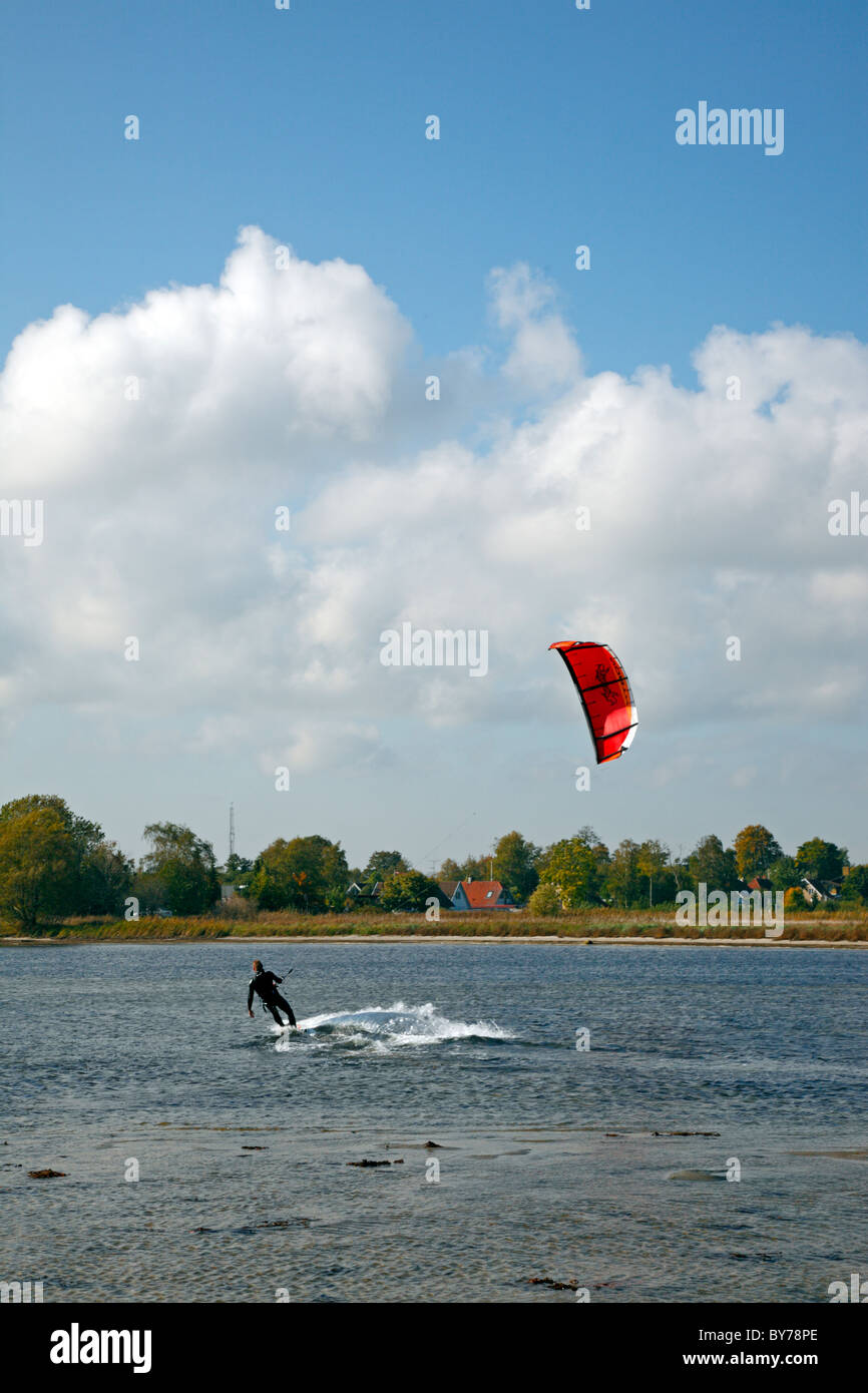 Kitesurfer navigando in acque poco profonde sul suono vicino alla costa un pomeriggio autunnale Foto Stock