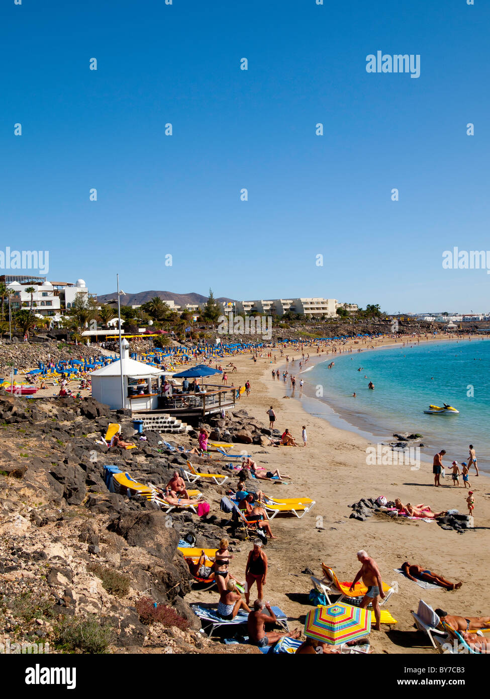 Occupato Playa Dorada Beach in Playa Blanca Lanzarote in un giorno caldo nei primi giorni di gennaio Foto Stock