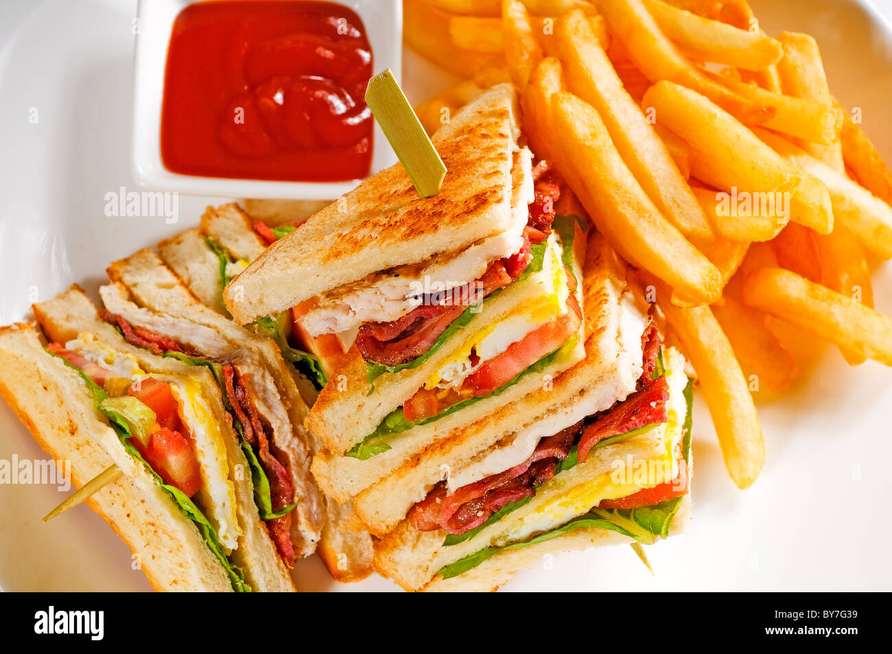 Fresh triple decker club sandwich con patatine fritte sul lato Foto Stock