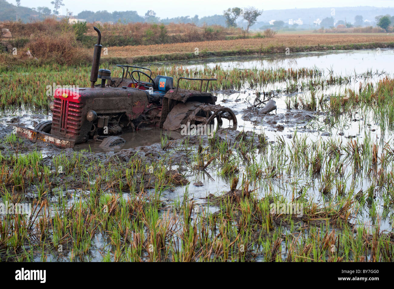 Indian trattore bloccato nel riso paddy fango. Andhra Pradesh, India Foto Stock