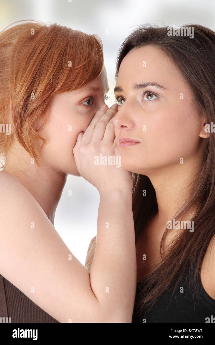Due giovani womans parlando gossip Foto Stock