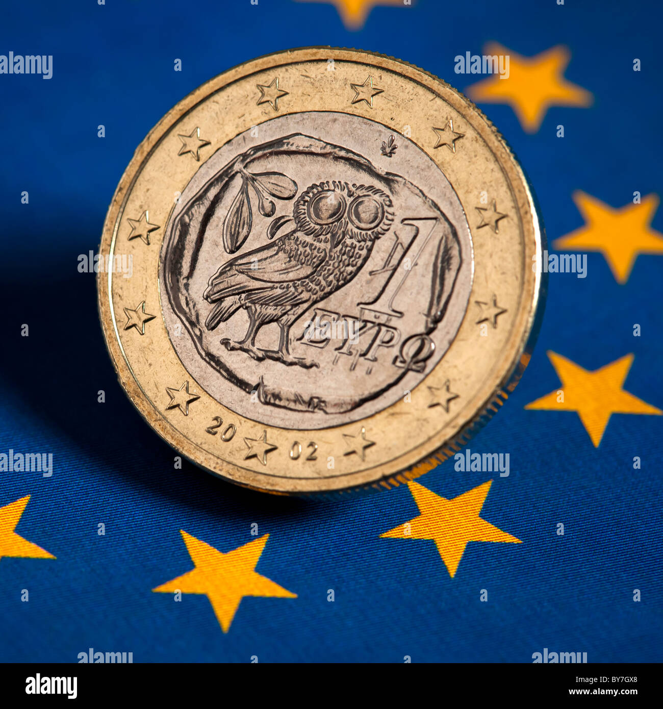Il greco Euro moneta sulla bandiera della Unione Europea Foto Stock
