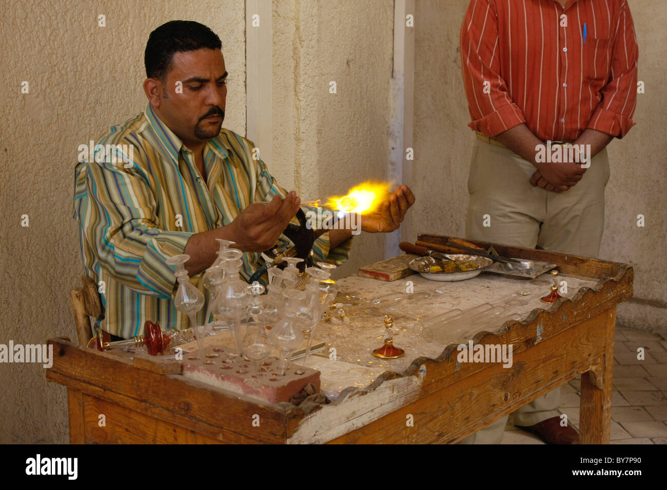 Artigiano egiziano il soffiaggio e lo stampaggio di vetro Bottiglie di profumo e ornamenti presso un negozio di souvenir di Luxor in Egitto. Foto Stock