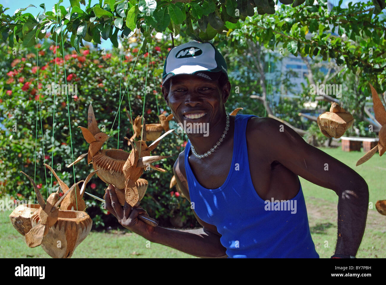 Uomo locale di vendita in legno intagliato bird bere/alimentazione di bocce, Castries, Santa Lucia, dei Caraibi. Foto Stock