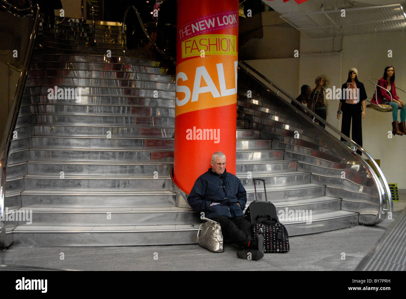 L'uomo stanco di shopping a Londra seduto esaurito Foto Stock