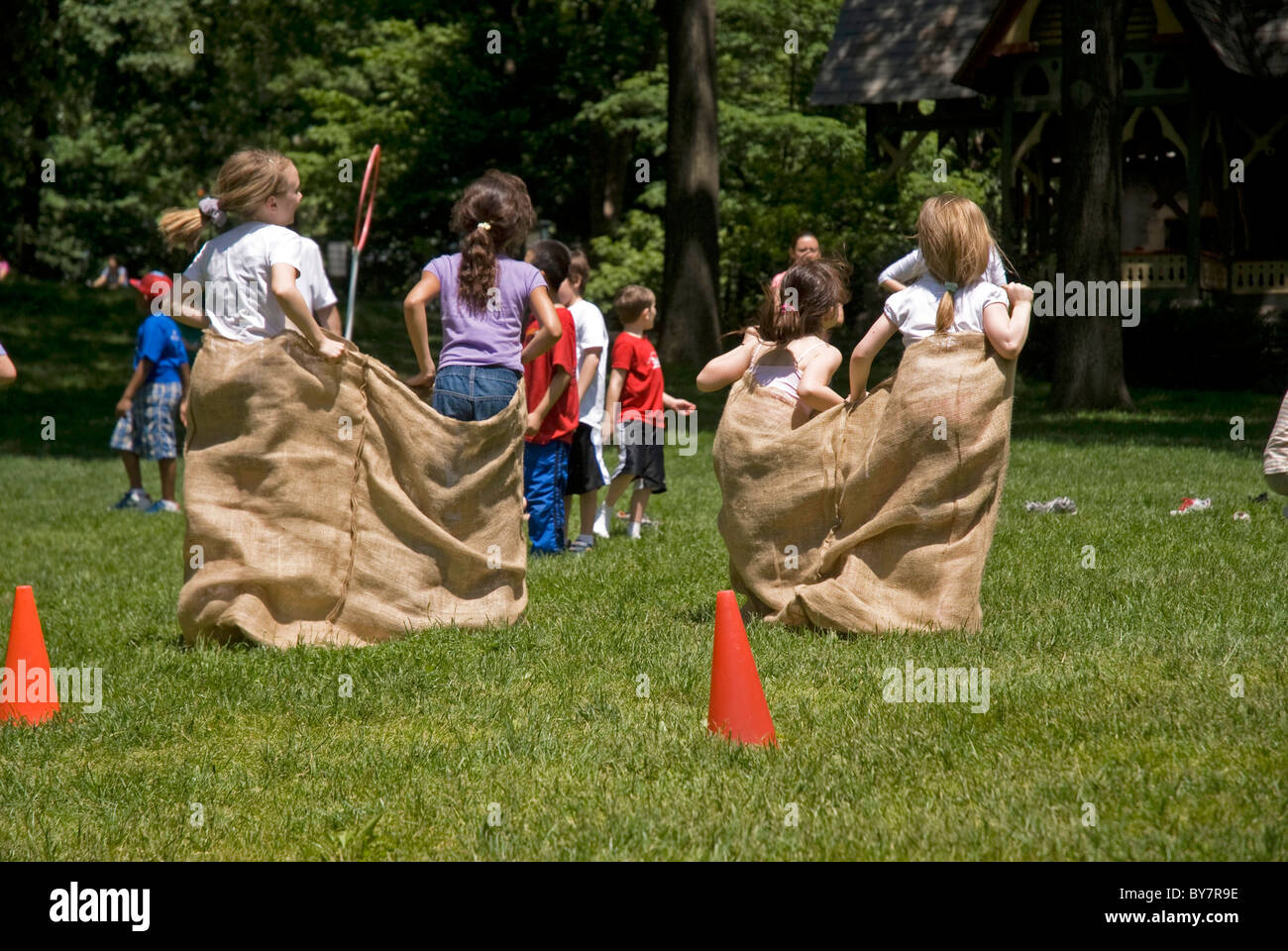 Bambini aventi il sacco gara nel parco Foto Stock