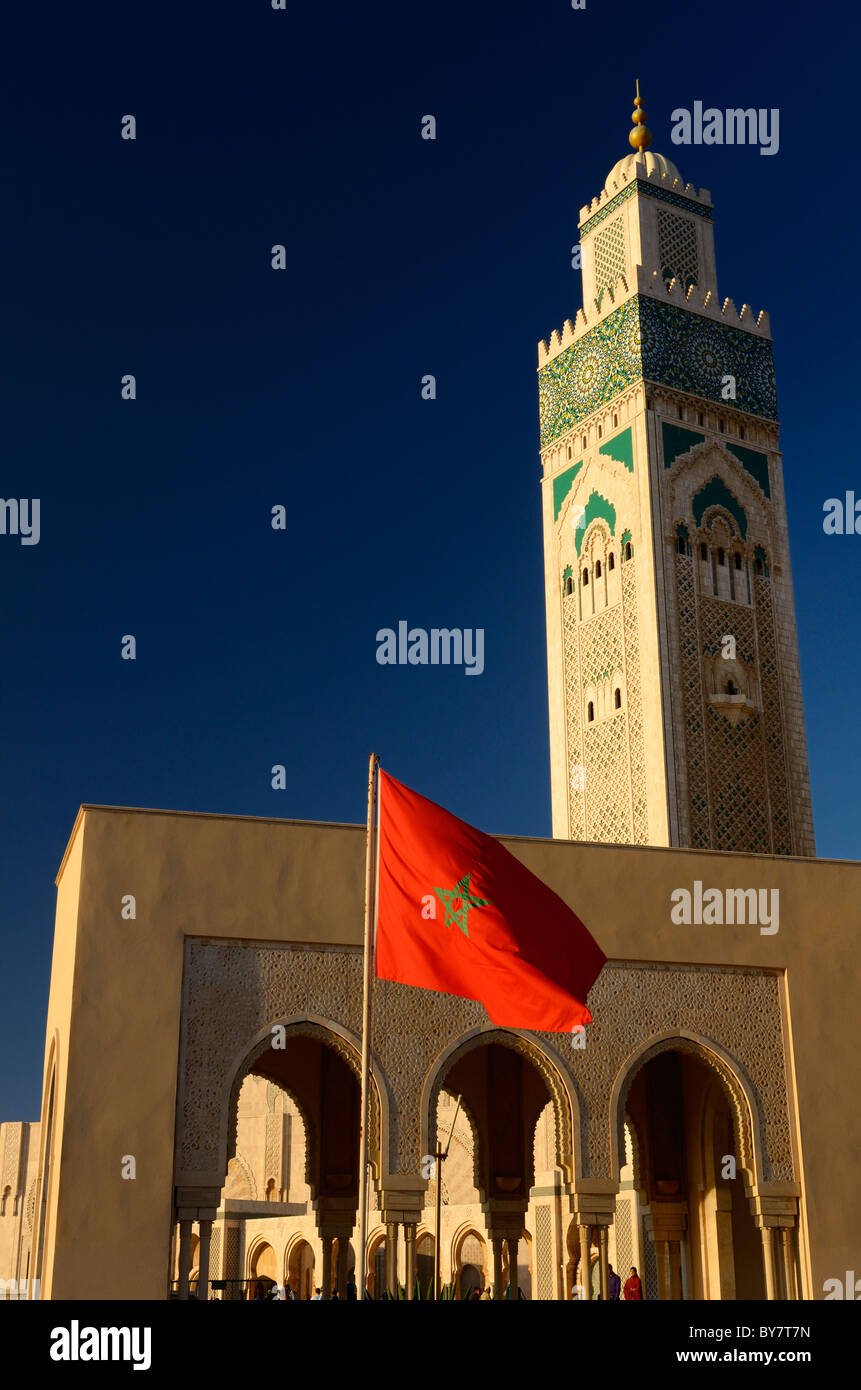 Bandiera del Marocco presso la moschea di Hassan II e minareto di Casablanca in Marocco con il blu del cielo Foto Stock