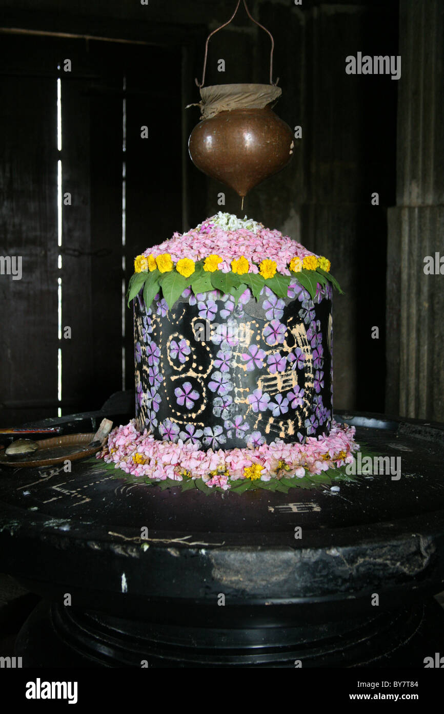 Fiore e decorate di vernice Shiva lingum in un tempio di Kumbalgarh Fort vicino a Udaipur, Rajasthan, India Foto Stock