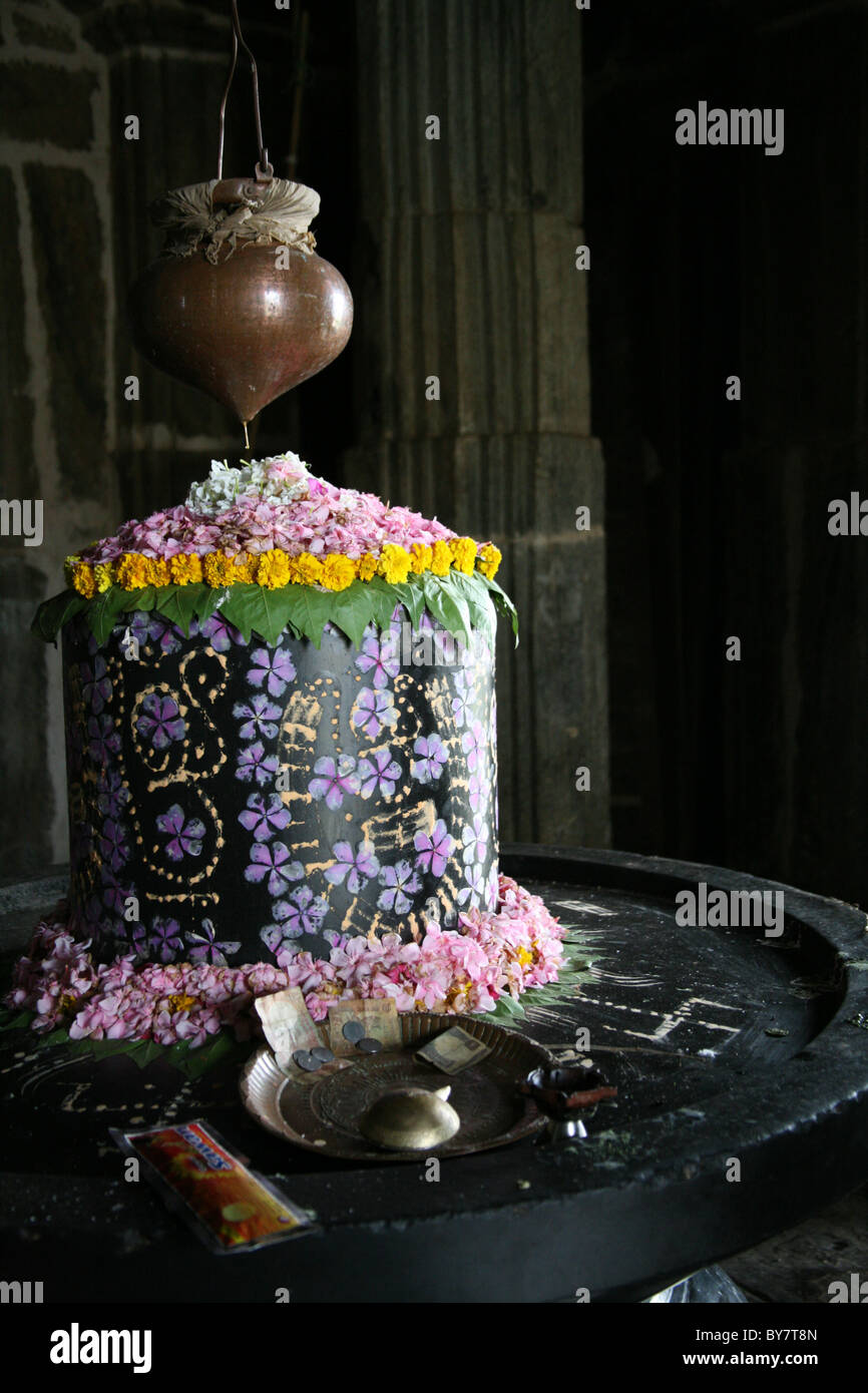 Fiore e decorate di vernice Shiva lingum in un tempio di Kumbalgarh Fort vicino a Udaipur, Rajasthan, India Foto Stock