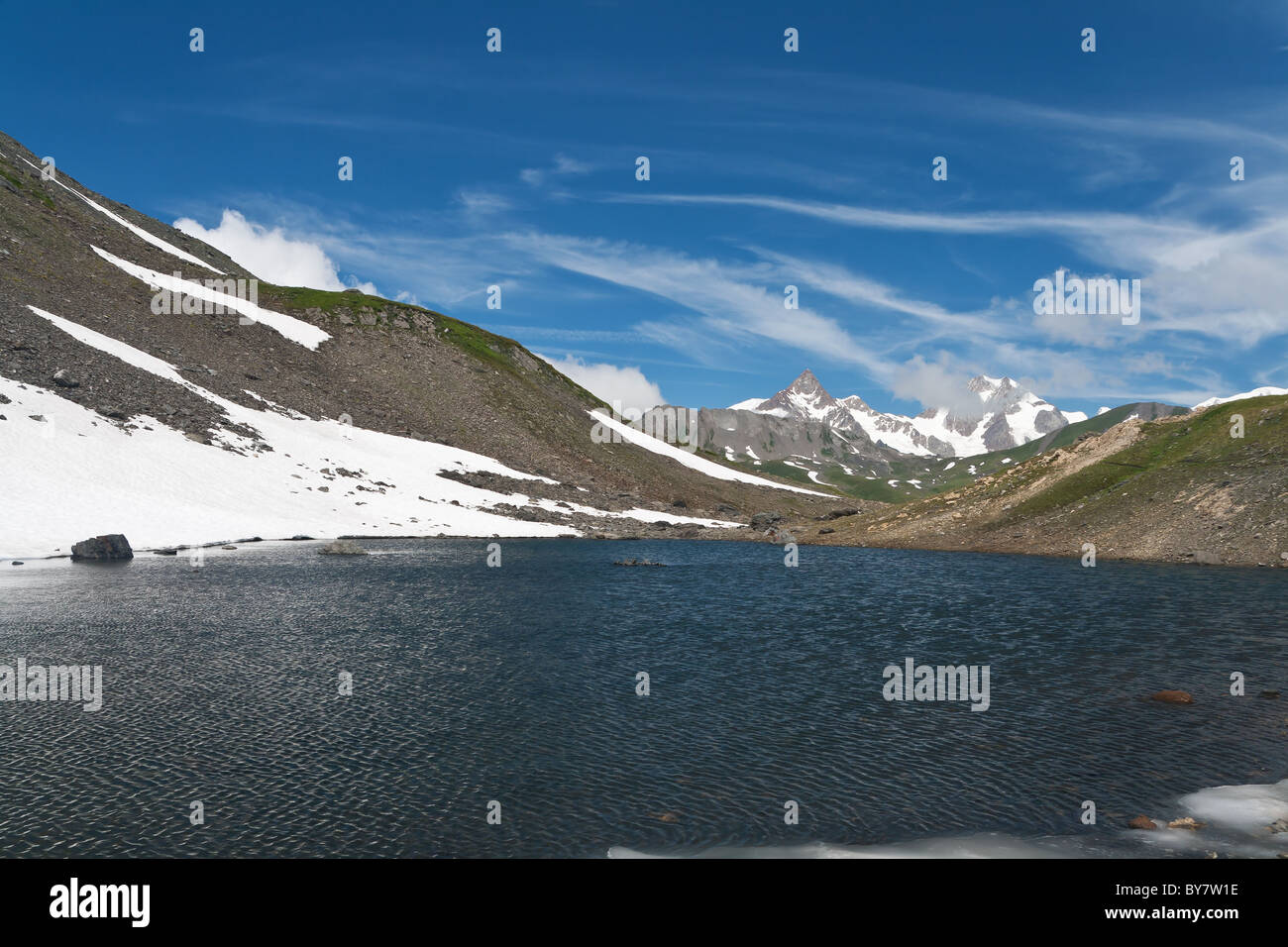 Piccolo lago in Pointe Rousse pass, Valle d'Aosta, Italia con il massiccio del Monte Bianco su sfondo Foto Stock