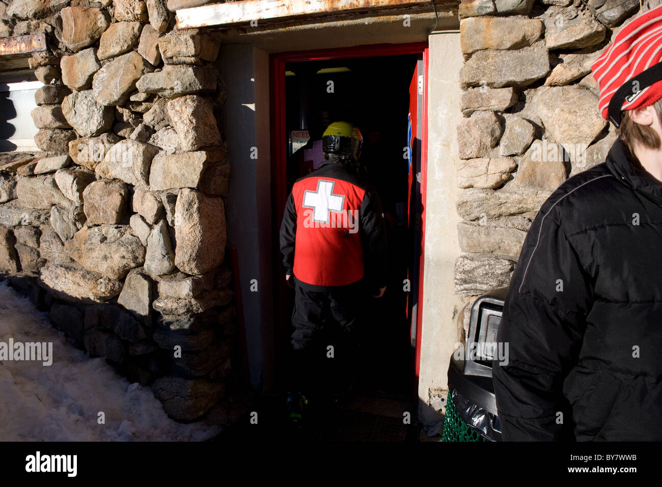 Primo soccorso camicia usurata in pista da sci medic assistenza medica di emergenza in montagna invernale Foto Stock