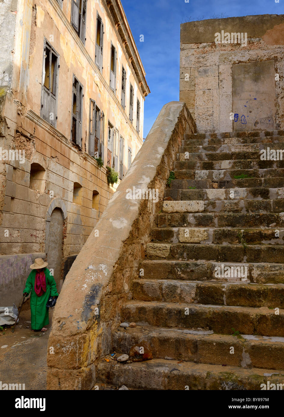 Donna vecchia a piedi nella medina della vecchia città portoghese di El Jadida Marocco con gradini in pietra Foto Stock