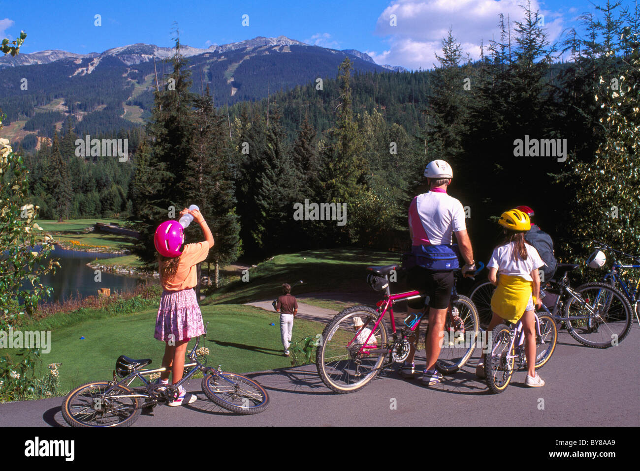 Famiglia Escursioni in bicicletta con biciclette smettere di guardare al campo da Golf e Blackcomb piste da sci, Whistler, BC, British Columbia, Canada, estate Foto Stock