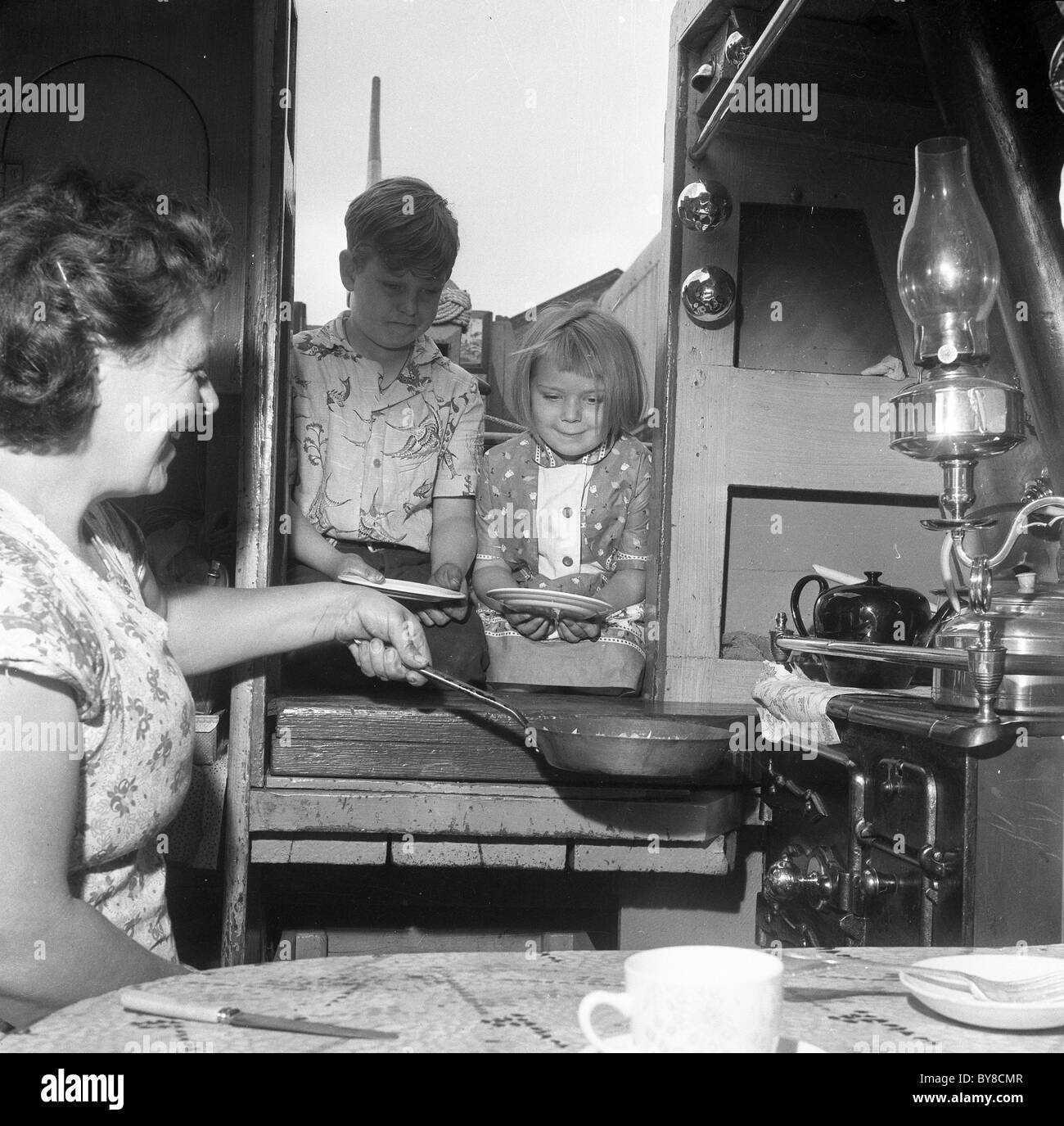 Una madre la cottura per bambini su narrowboat area di Wolverhampton 1960 Foto Stock