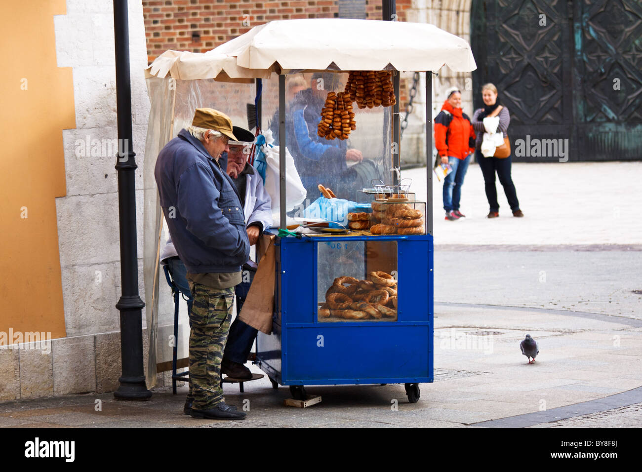 Due uomini vendita pretzel in Rynek Glowny la Piazza del Mercato di Cracovia in Polonia Foto Stock