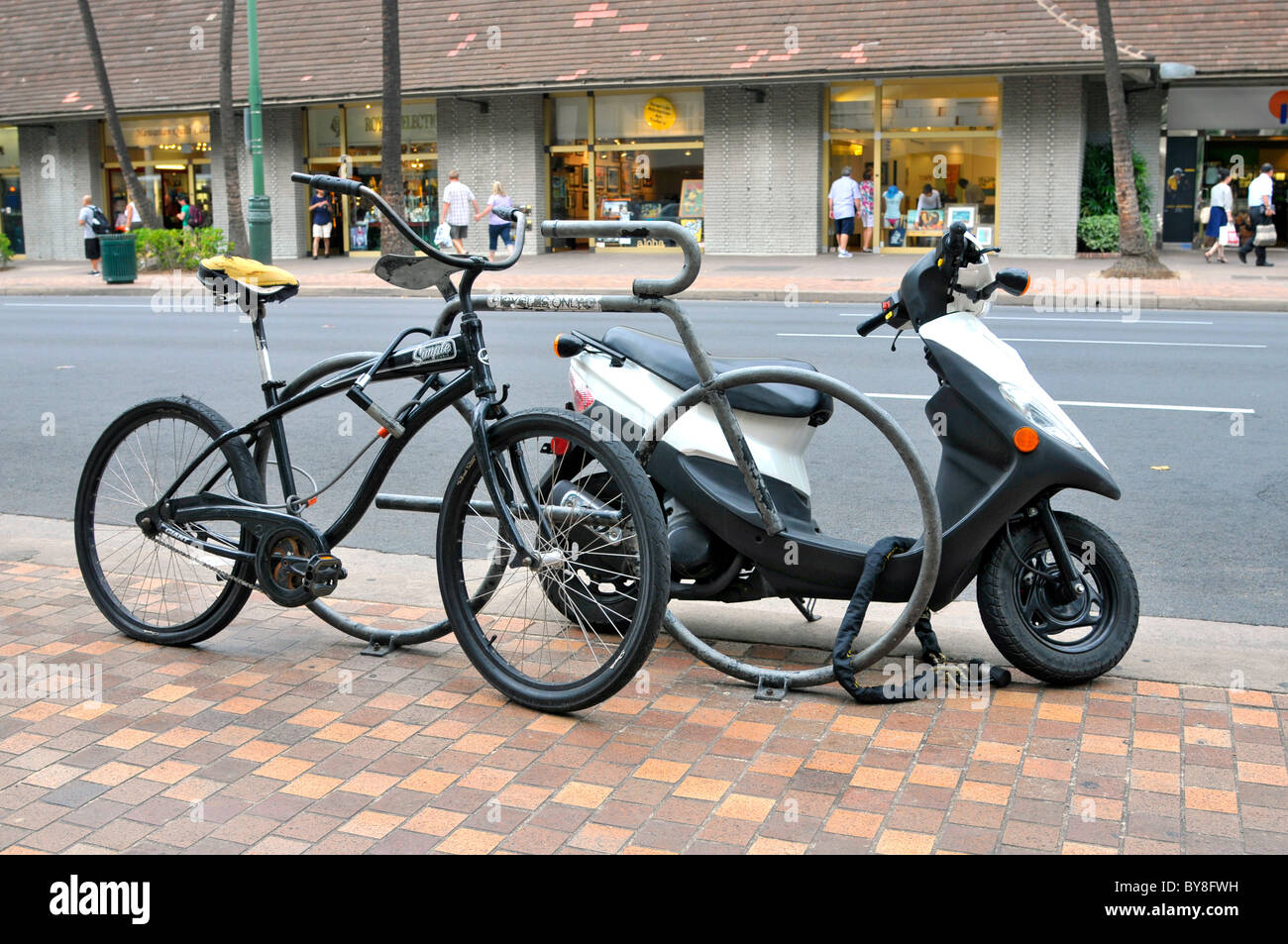 Moto e bicicletta bloccato in rack su Kalakaua Ave lungo la spiaggia di Waikiki Hawaii Honolulu Foto Stock