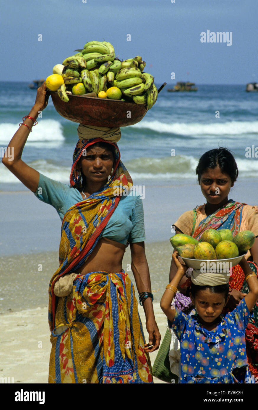 Goa, India - Donne e una bambina il trasporto di frutta Foto Stock