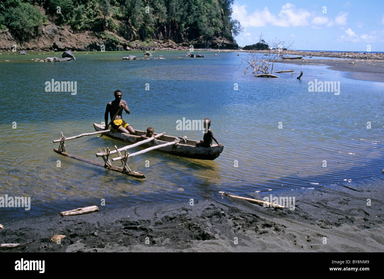 Il Melanesian l uomo e i suoi figli in un tradizionale piroga in estuario presso la baia di zolfo, Tanna, Vanuatu. Foto Stock