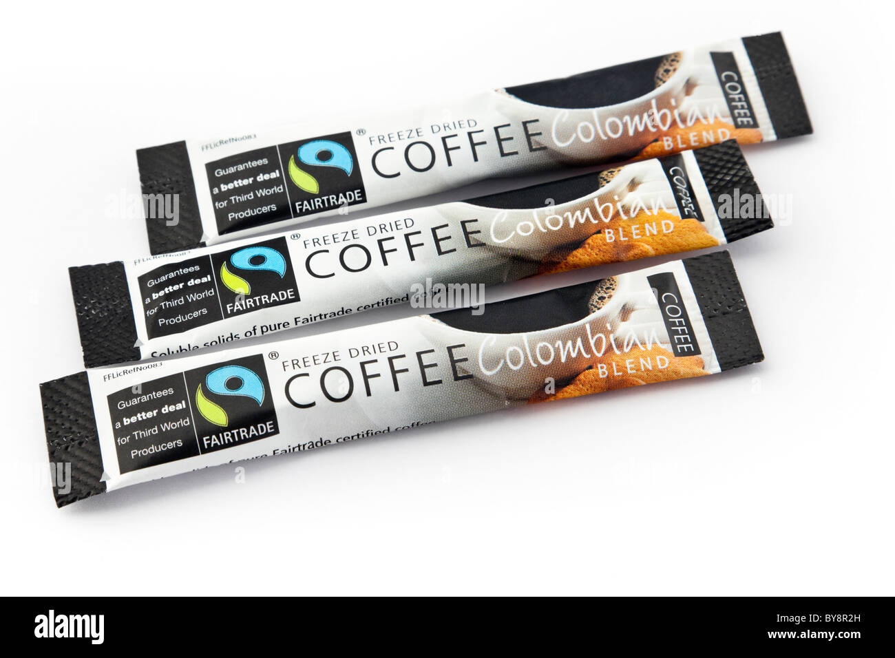 Fairtrade etichette e logo su tre singole dosi di liofilizzato Columbian caffè istantaneo bustine su uno sfondo bianco. Inghilterra, Regno Unito Foto Stock