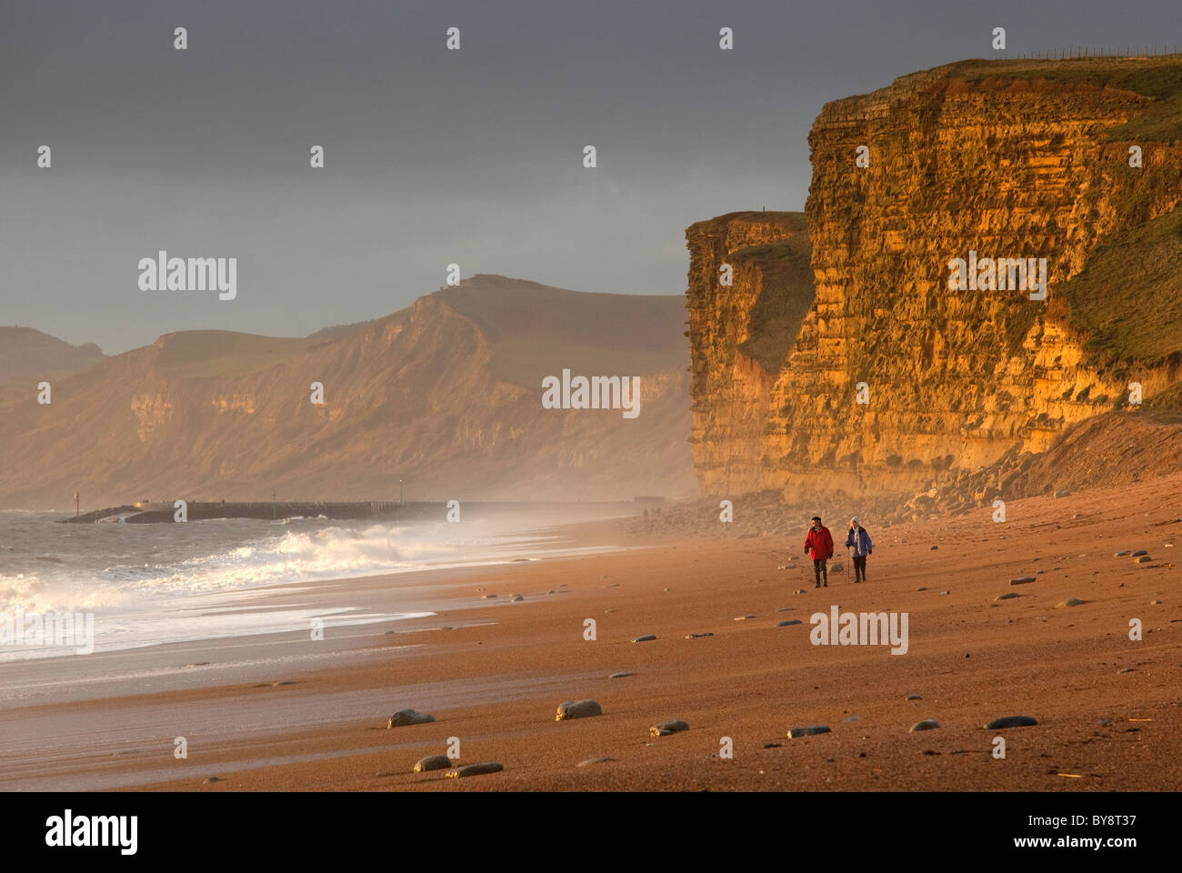 Giovane a piedi lungo la spiaggia di Burton Bradstock sul patrimonio di Dorset costa, l'Inghilterra del Sud Foto Stock