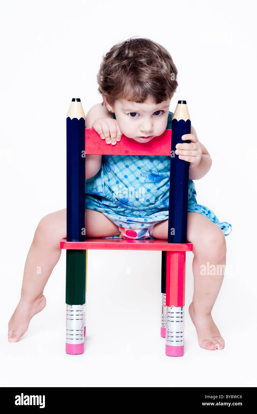 Ragazza seduta di un sedile per bambino rivolto verso la parte anteriore Foto Stock