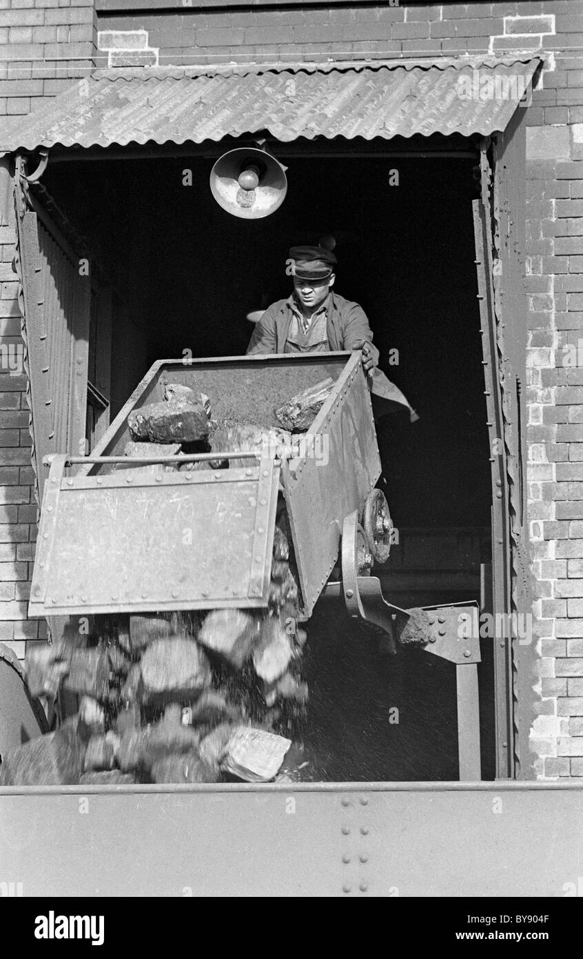 Operaio ferroviario che riempie il tender di carbone sulla locomotiva a vapore a Wolverhampton 1967 foto di DAVID BAGNALL Foto Stock