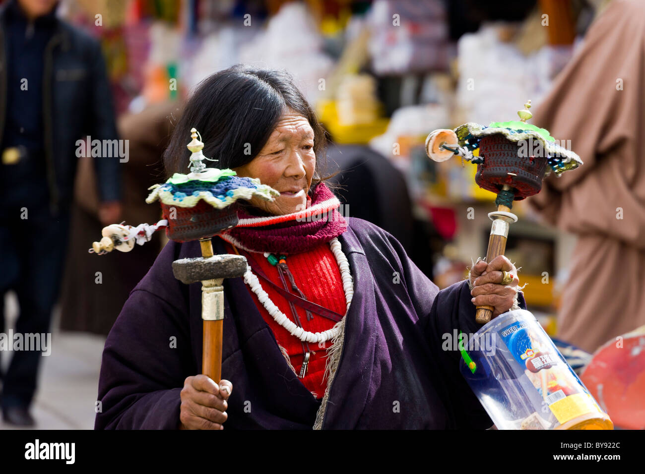 Donna tibetana pellegrino la filatura due ruote della preghiera del Barkhor, Lhasa, in Tibet. JMH4473 Foto Stock