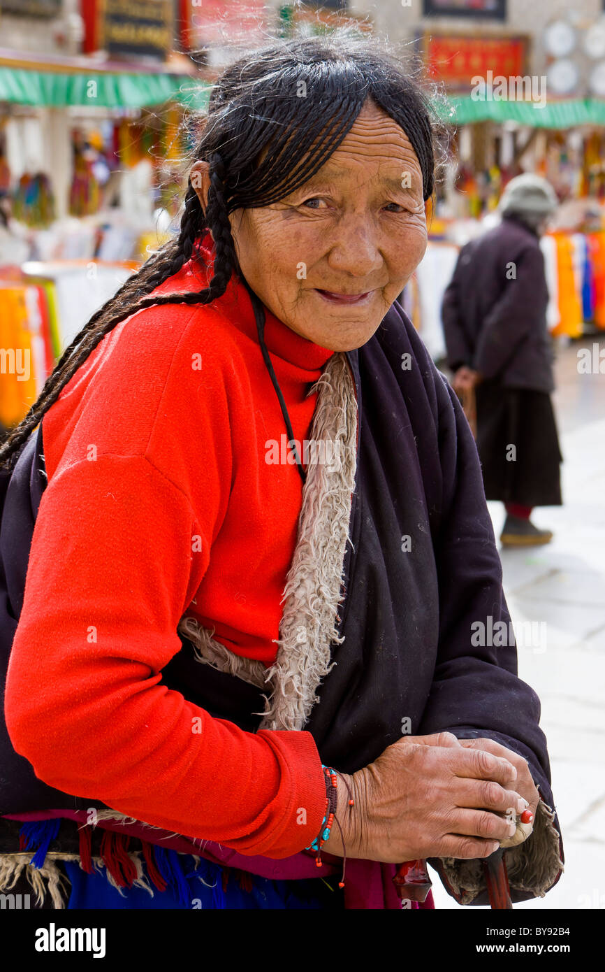 Vecchio donne tibetane pellegrino indossando ponticello rosso del Barkhor, Lhasa, in Tibet. JMH4488 Foto Stock