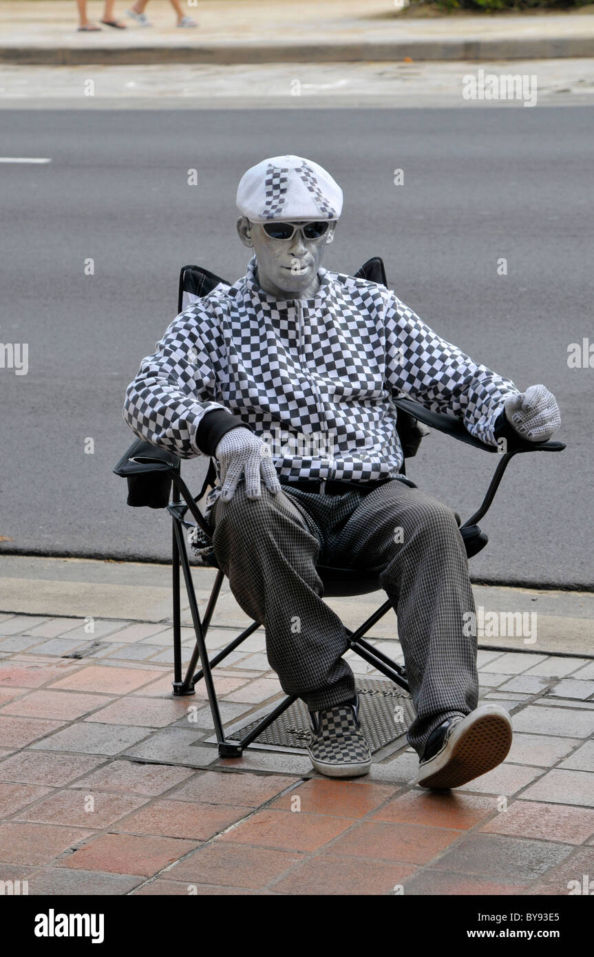 Uomo compie come statua d'argento per suggerimenti su Kalakaua Ave lungo la spiaggia di Waikiki Hawaii Honolulu Foto Stock