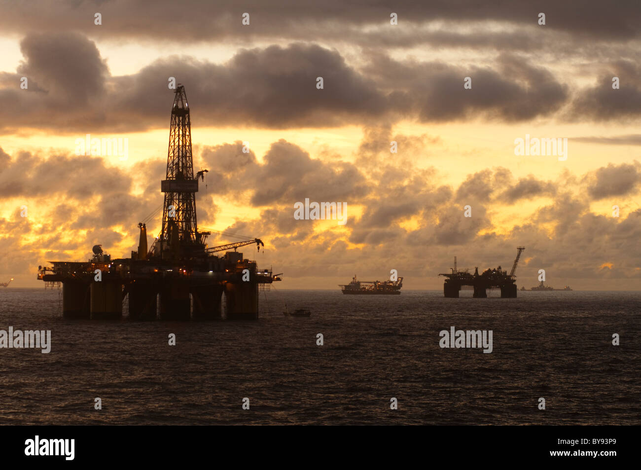 Impianti di trivellazione del petrolio e la fornitura delle navi nel bacino di Campos, stato di Rio de Janeiro, Brasile, durante l'orario del tramonto. 2011 Foto Stock