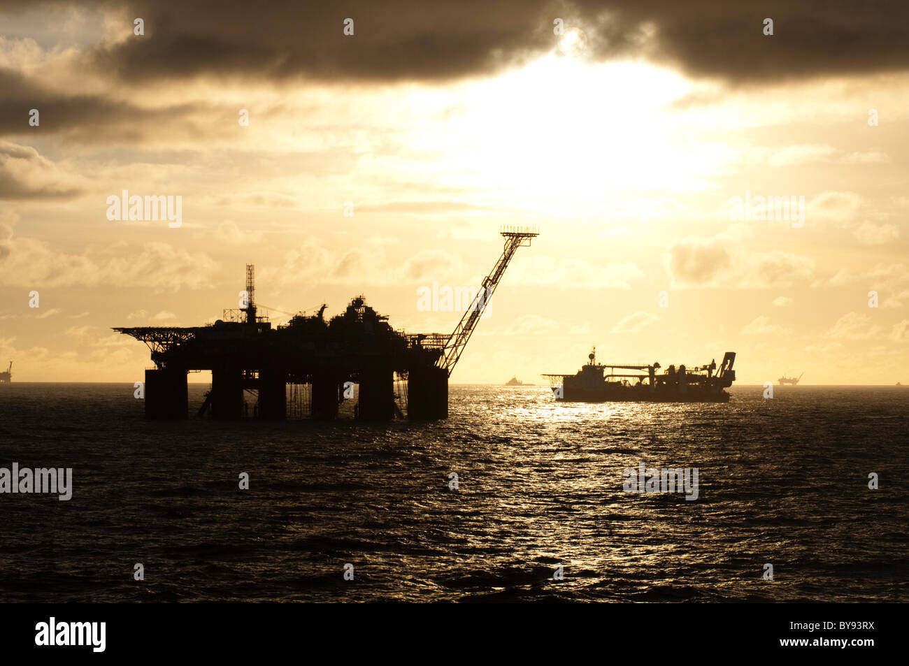Impianti di trivellazione del petrolio e la fornitura delle navi nel bacino di Campos, stato di Rio de Janeiro, Brasile, durante l'orario del tramonto. 2011 Foto Stock