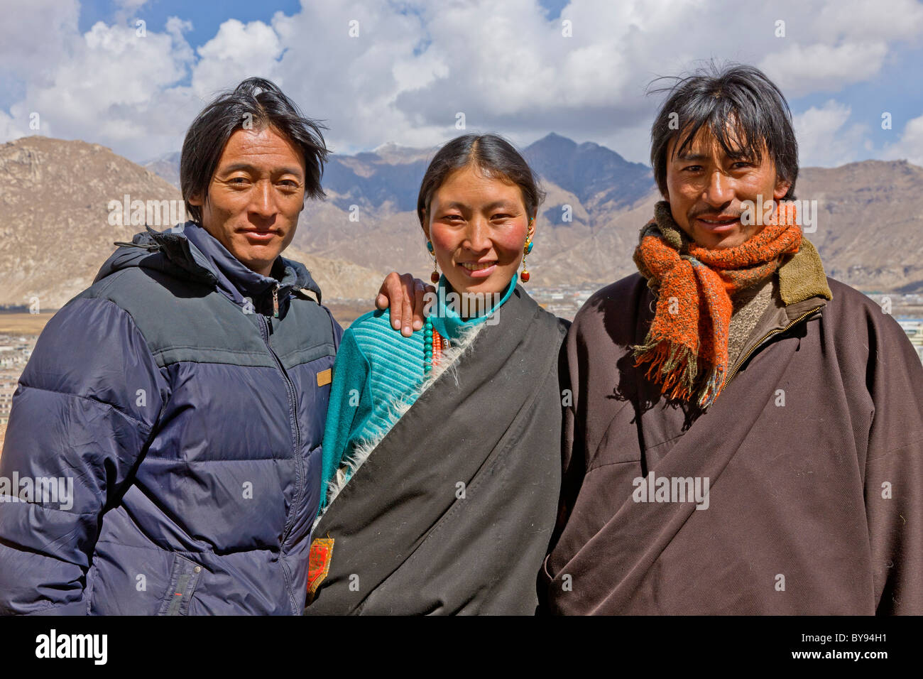 Il Tibetano moglie con i suoi due mariti pellegrini nomadi al di fuori del palazzo del Potala Lhasa il Tibet. JMH4577 Foto Stock