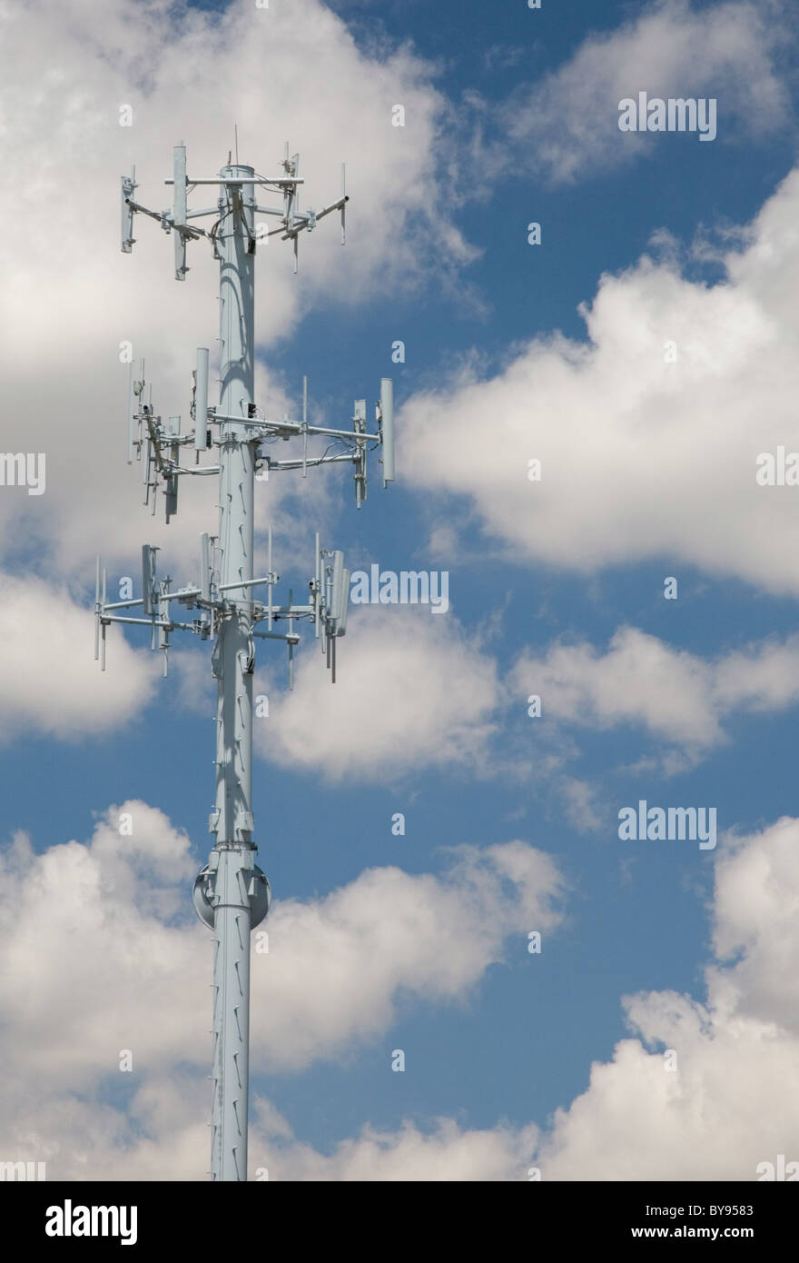 Cellular Telecommunications Tower contro un nuvoloso cielo blu. Foto Stock