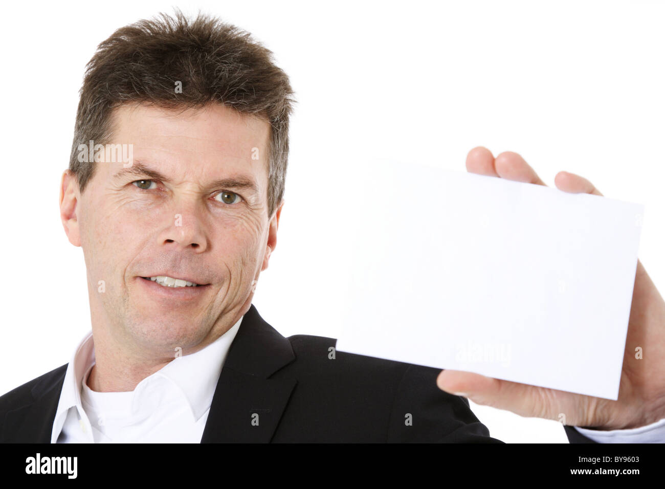 Attraente uomo di mezza età tenendo business card. Tutto su sfondo bianco. Foto Stock