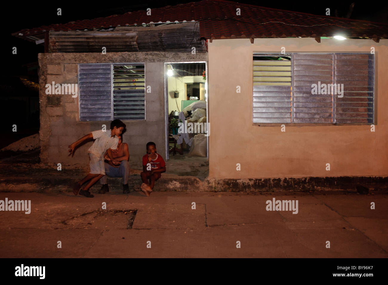 I bambini di fronte a un cubano di casa in un piccolo villaggio di notte Foto Stock