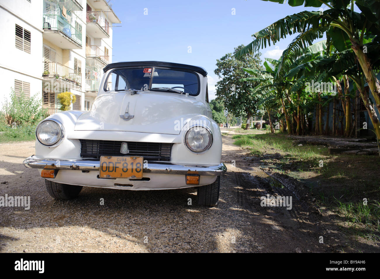 Vecchio classico bianco convertibile automobile parcheggiata di fronte agli edifici in città cubane. Foto Stock