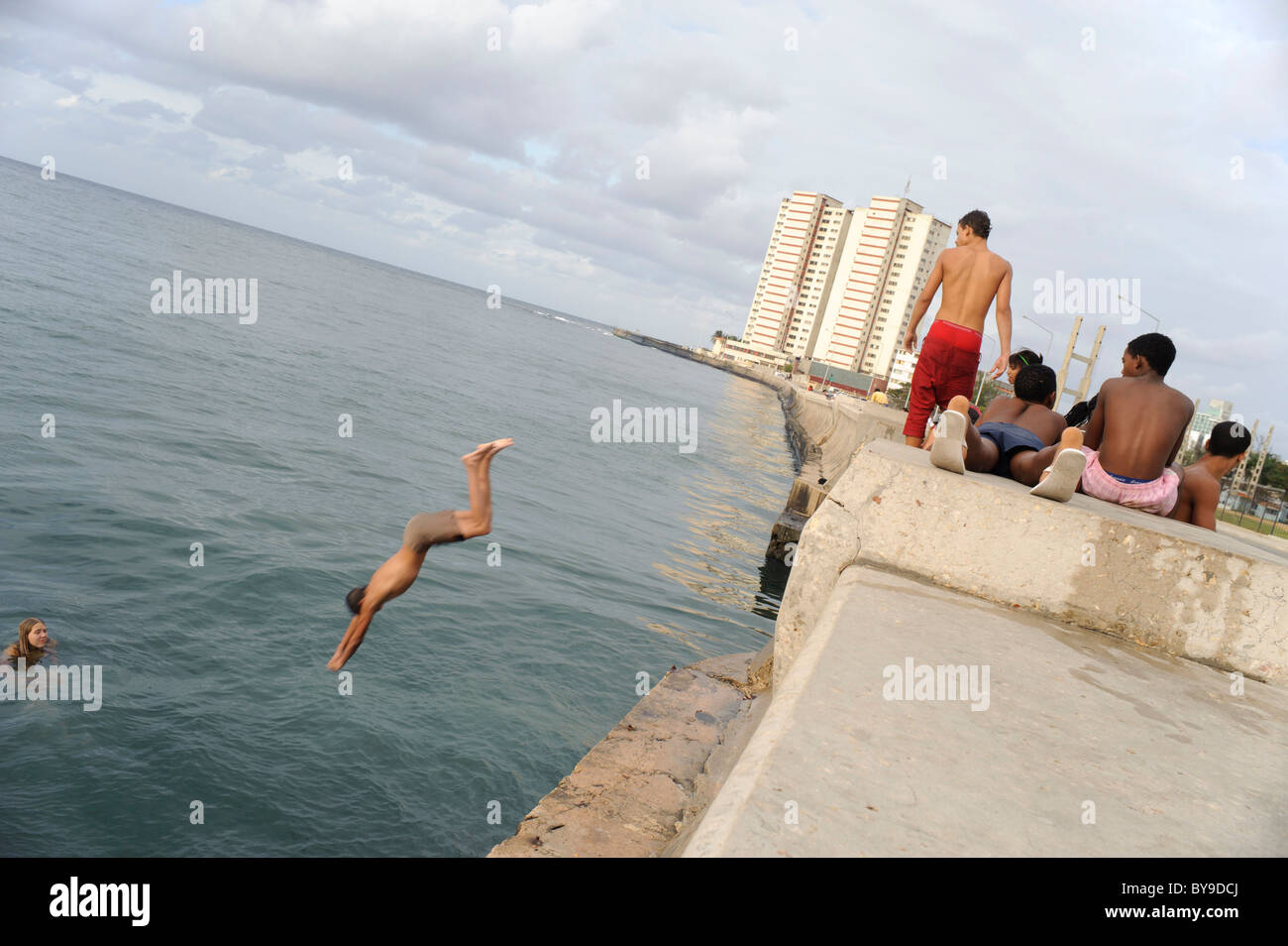 I bambini cubani giocando e immersioni in mare dal Malecon a l'Avana. Cuba. Foto Stock