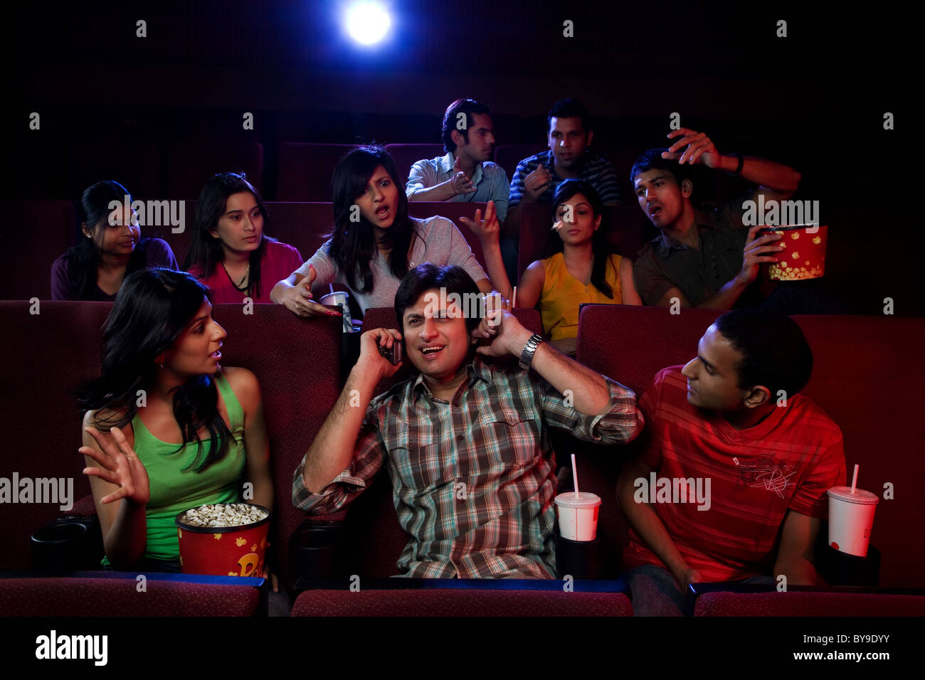 Persone fissando un uomo dentro una sala cinematografica Foto Stock