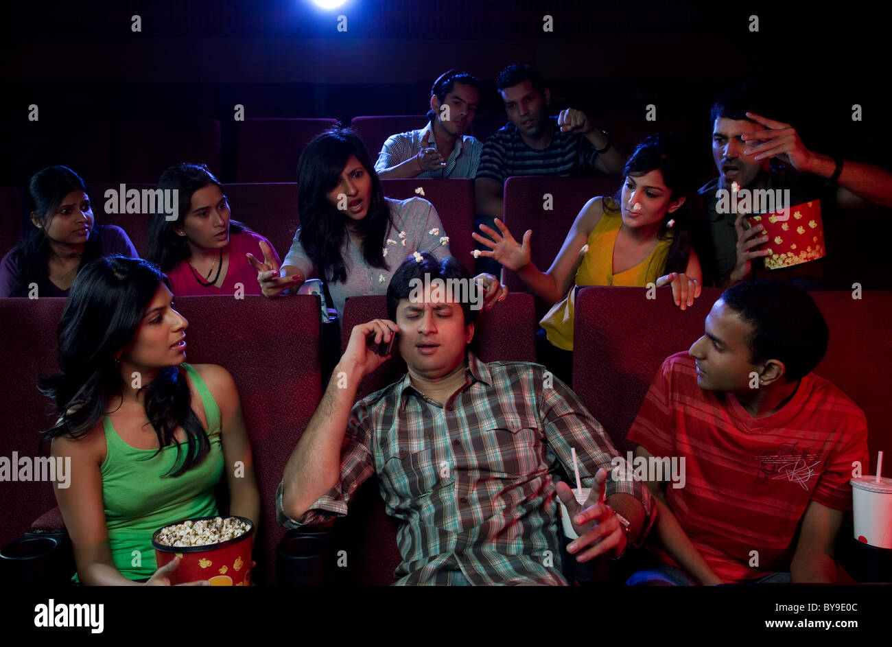 Uomo che parla di un telefono cellulare in una sala cinematografica Foto Stock