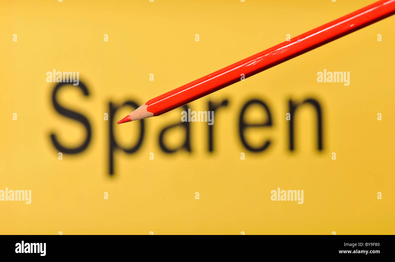 Matita rossa nella parte anteriore del fuori fuoco parola Sparen, tedesco per il salvataggio Foto Stock