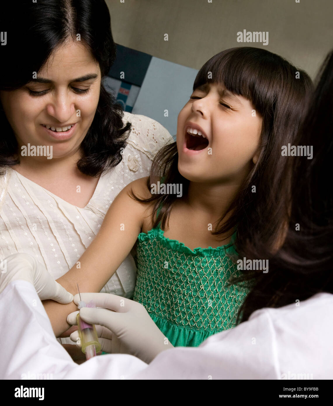 Medico di prendere un campione di sangue da una ragazza Foto Stock