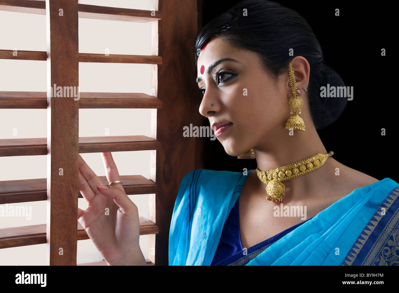 Bengali donna che guarda fuori da una finestra Foto Stock