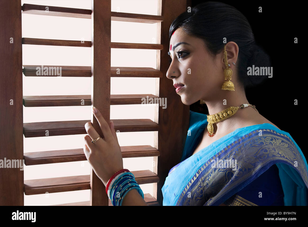 Bengali donna che guarda fuori da una finestra Foto Stock