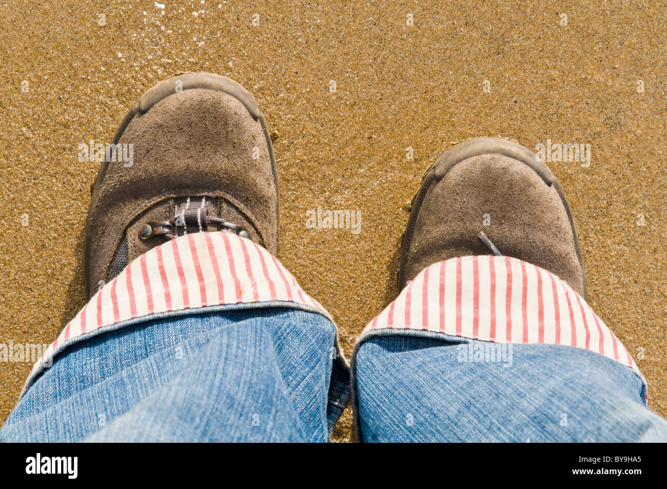 Coppia di piedi / gambe in piedi su una spiaggia Foto Stock